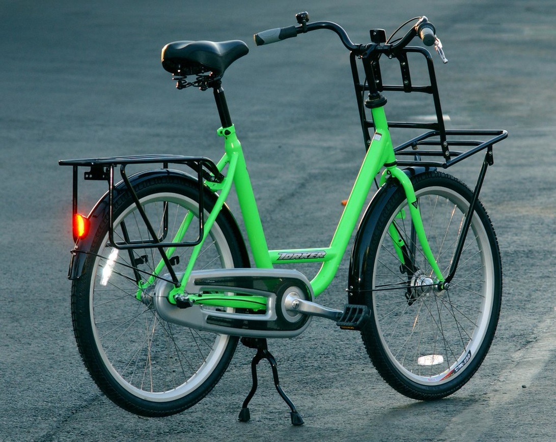 Een groene stadsfiets met bagagedragers voor en achter, klaar voor een fietstocht.