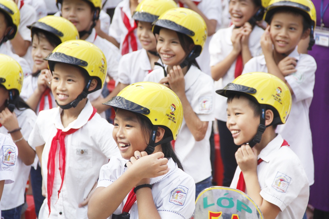 Groep schoolkinderen met gele veiligheidshelmen.