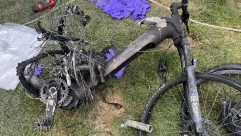 Zwaar beschadigde elektrische fiets op het gras na schade
