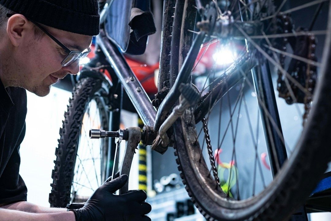 Monteur inspecteert een gebruikte fiets bij het achterwiel